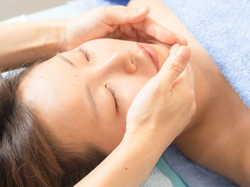 目を閉じたお客様のお顔を両手で包むようにほぐす様子